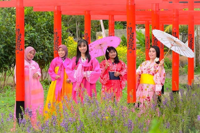 Para perempuan dengan pakaian kimono di kebun bunga