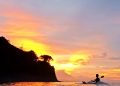 Wisatawan menikmati keindahan sunset di pantai pandanan dari atas kano