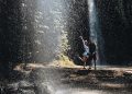 Dua orang wisatawan terlihat ceria bermain air di Air Terjun Benang Stokel