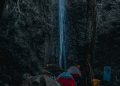 Pemandangan tenda camping di depan jatuhnya air terjun Timponan