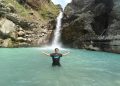 wisatawan berada di tengah kolam dengan air berwarna hijau di Air Terjun Umar Maya