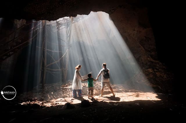 keluarga berfoto di dalam gua yang disekelilingi tembok-tembok gua