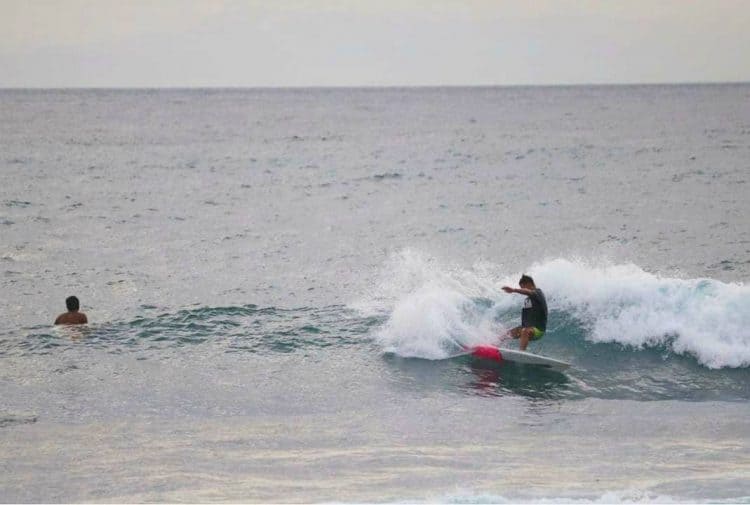 Wisatawan surfing di ombak Pantai Kerandangan