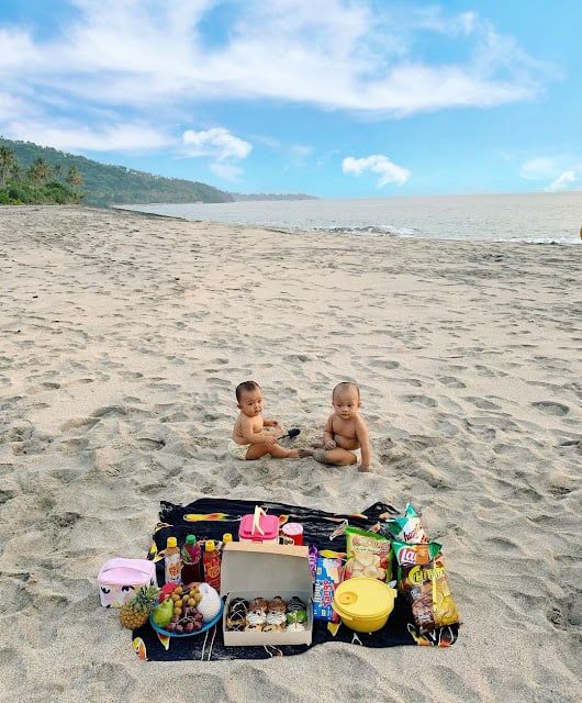 dua bayi duduk di pinggir pantai dengan pasir dan pemandangan indah di Pantai Setangi