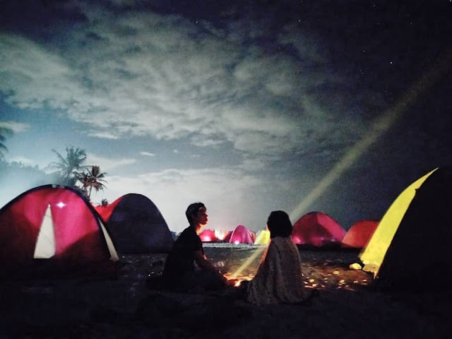 pemandangan malam hari di pinggir Pantai Setangi dengan tenda camping