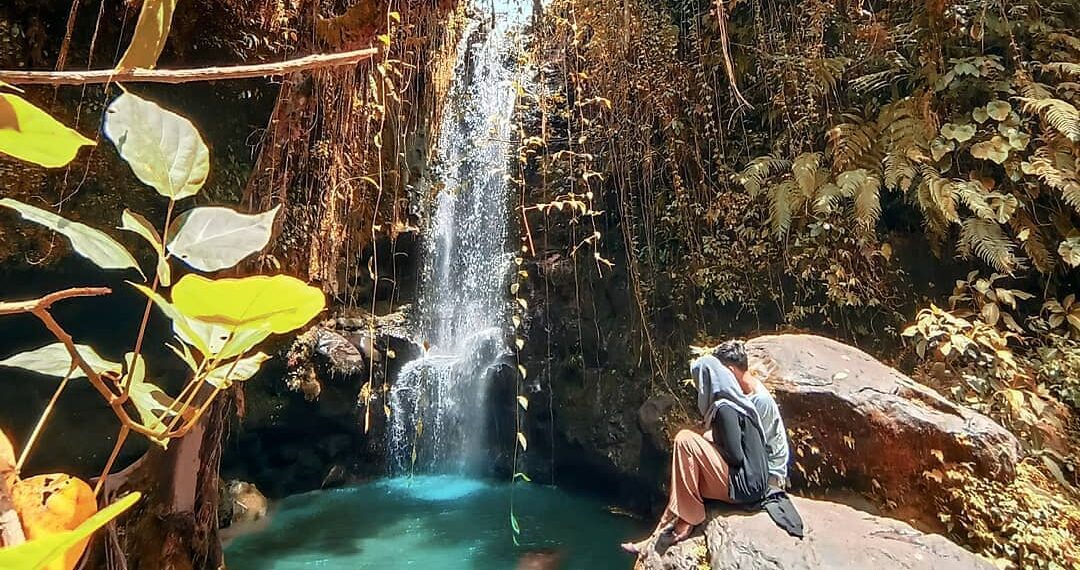 Wisatawan duduk di batu yang ada di Air Terjun Tibu Elen