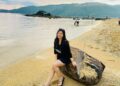 Wisatawan duduk di atas batu tepi Pantai Kuta Lombok