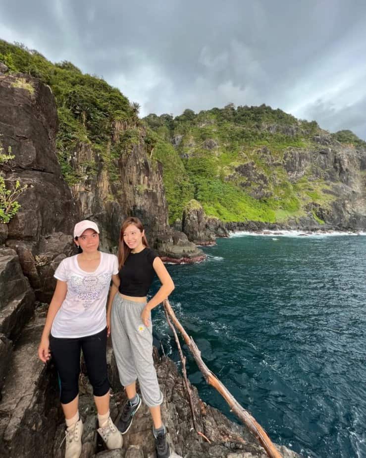 Dua wisatawan berada di tepi Pantai Orong Bukal