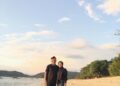 Dua wisatawan berjalan di tepi Pantai Jelenga