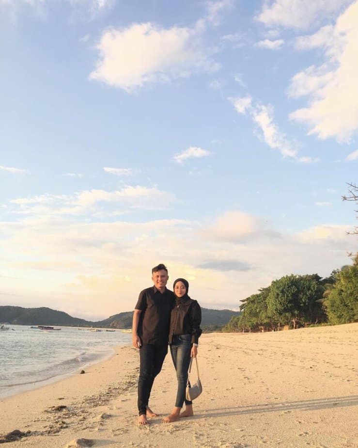 Dua wisatawan berjalan di tepi Pantai Jelenga
