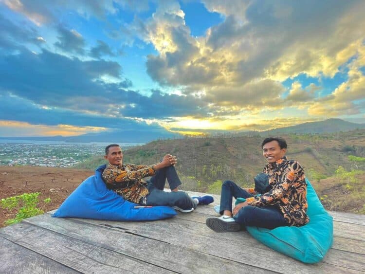Dua pria sedang bersantai menikmati sunset diatas puncak Bukit Jatiwangi