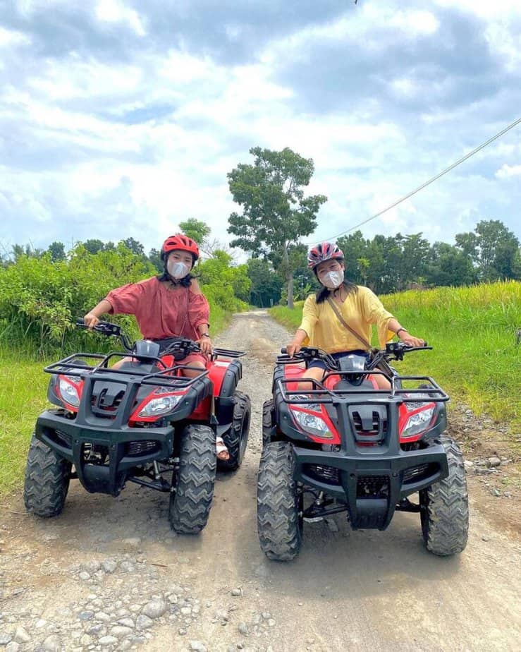 Dua wisatawan menggunakan ATV mengelilingi sawah