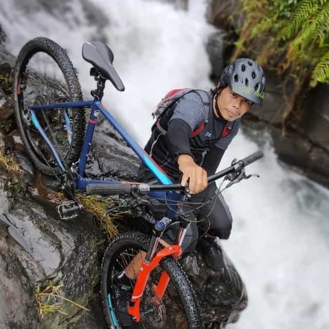 Pesepeda berada di atas tebing air terjun