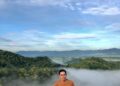 Wisatawan berada di puncak Doro Wadu Nae dengan latar bukit dan awan