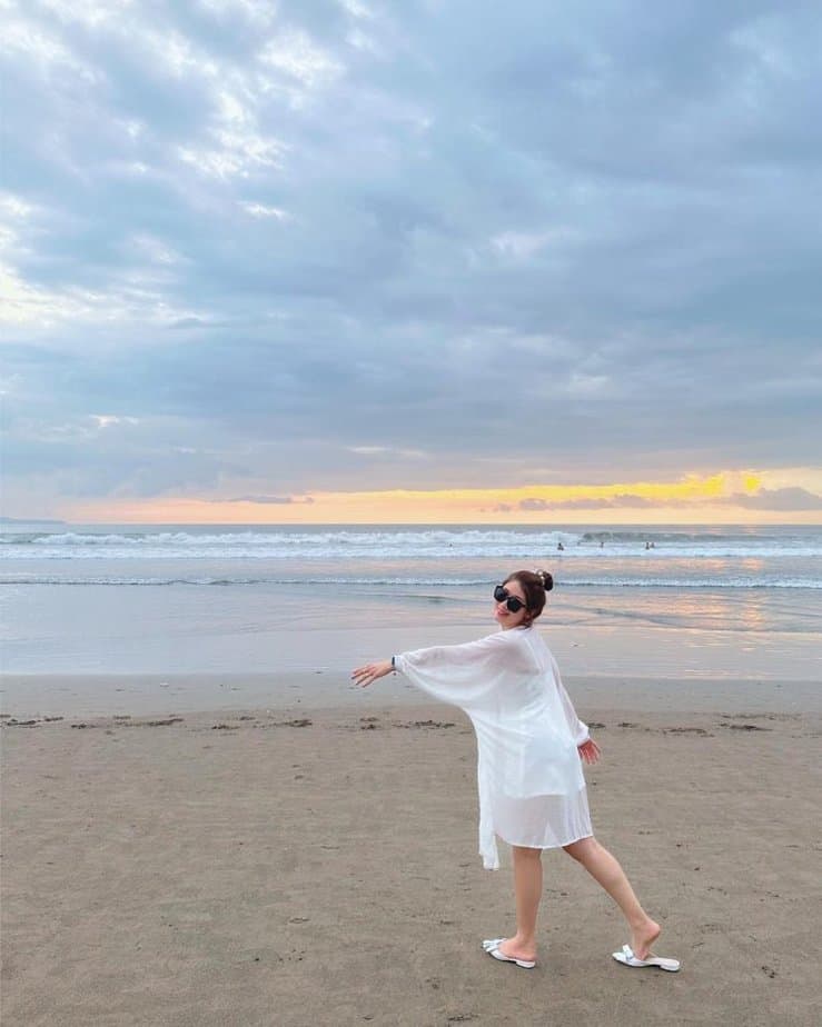 Wisatawan dengan baju putih berada di Pantai Seminyak Bali