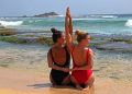 Wisatawan melakukan yoga di tepi pantai