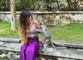 Wisatawan bersama seekor monyet di taman