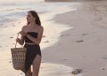 Wisatawan asing berjalan di tepi pantai dengan membawa keranjang
