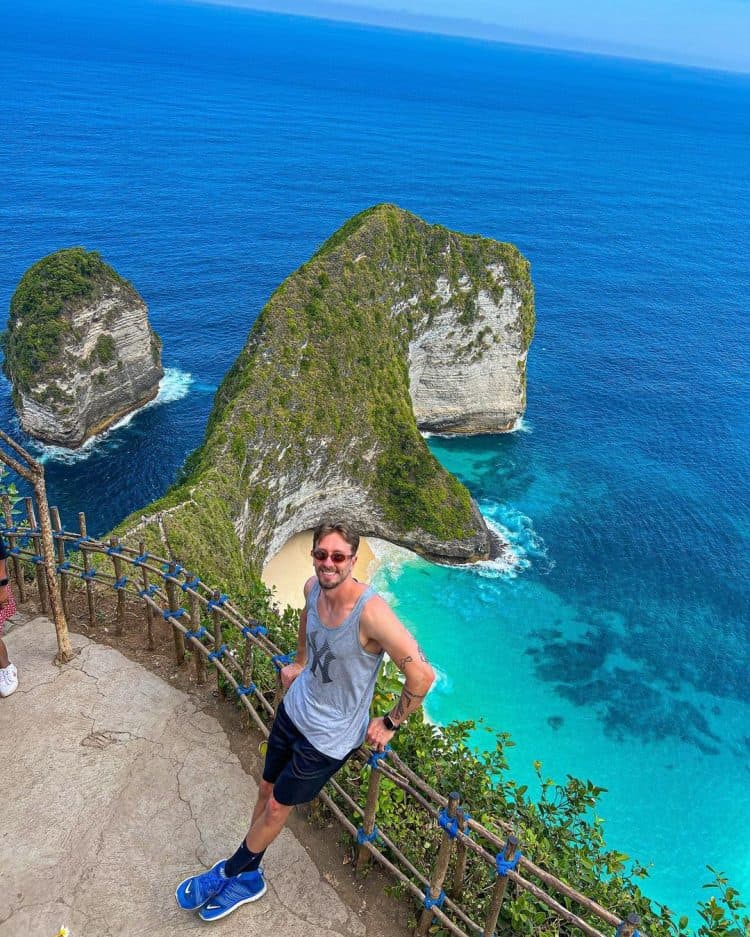 Wisatawan asing bersandang di pembatas anak tangga di Pantai Kelingking Bali