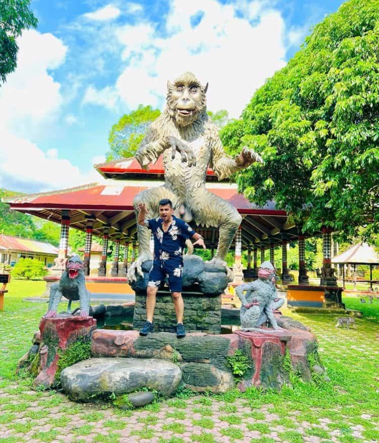 Wisatawan berdiri di depan patung Monkey di Alas Kedaton